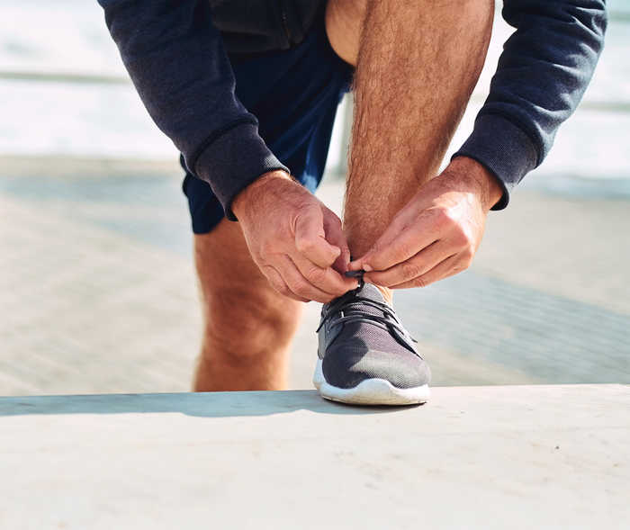 Leben mit NET: Ein NET-Patient schnürrt sich die Sportschuhe zu
