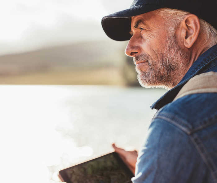 Leben mit NET: Ein Mann schaut nachdenklich über einen See