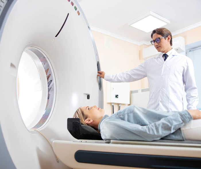 Leben mit NET: Eine Frau wird in einen Computertomografen geschoben