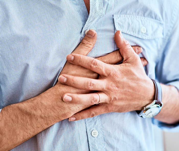 Leben mit NET: Ein Mann fasst sich mit beiden Händen an seine linke Brustseite