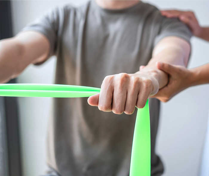 Leben mit NET: Ein Patient trainiert seine Mobilität mihilfe eines Expanderbandes