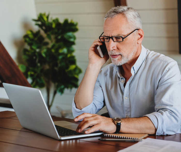 Leben mit NET: EIn Patient recherchiert mit Telefon und Notebook nach weiteren Informationen Leben mit NET: EIn Patient recherchiert mit Telefon und Notebook nach weiteren Informationen