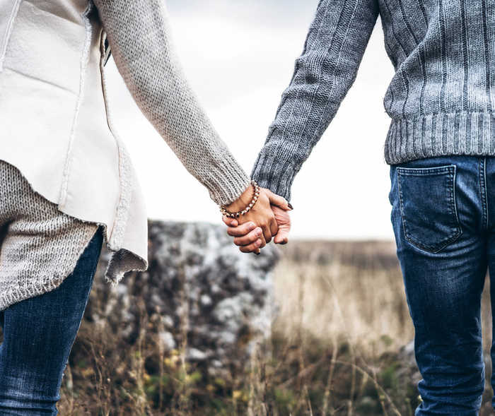 Leben mit NET: Ein Paar geht Hand in Hand über einen Feldweg