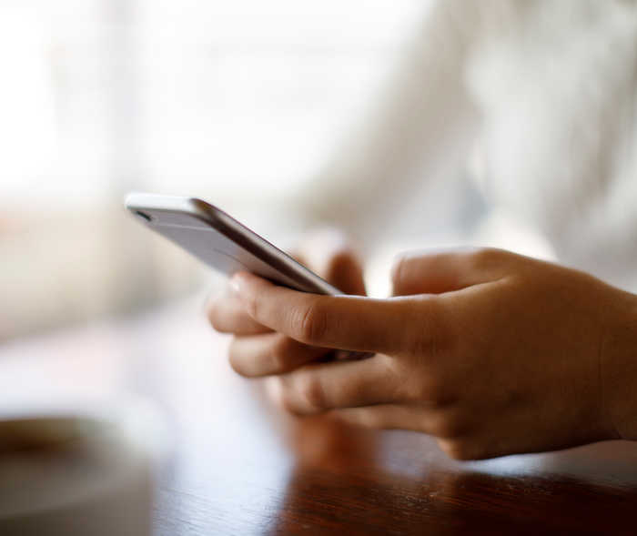 Leben mit NET: Ein Patientin tippt auf ihrem Smartphone