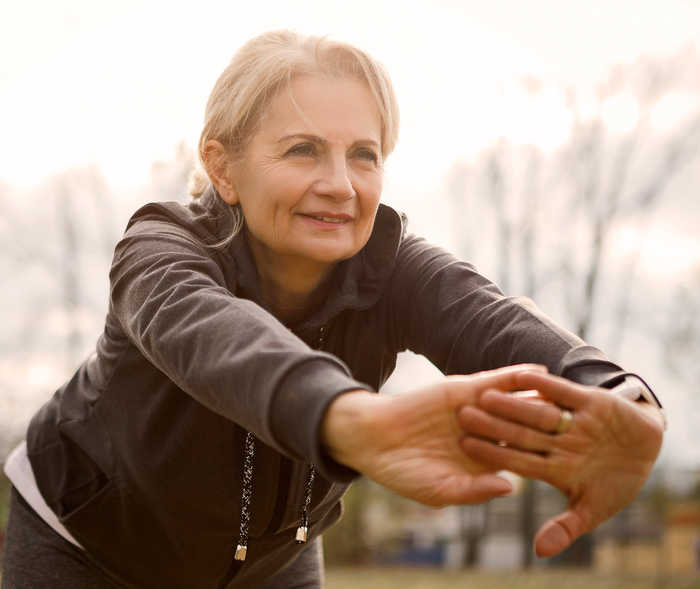 Leben mit NET: Eine Patientin nach vorn gebeugt bei Dehnübungen