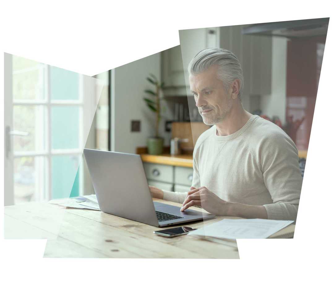 Ein grauhaariger Mann benutzt seinen Laptop