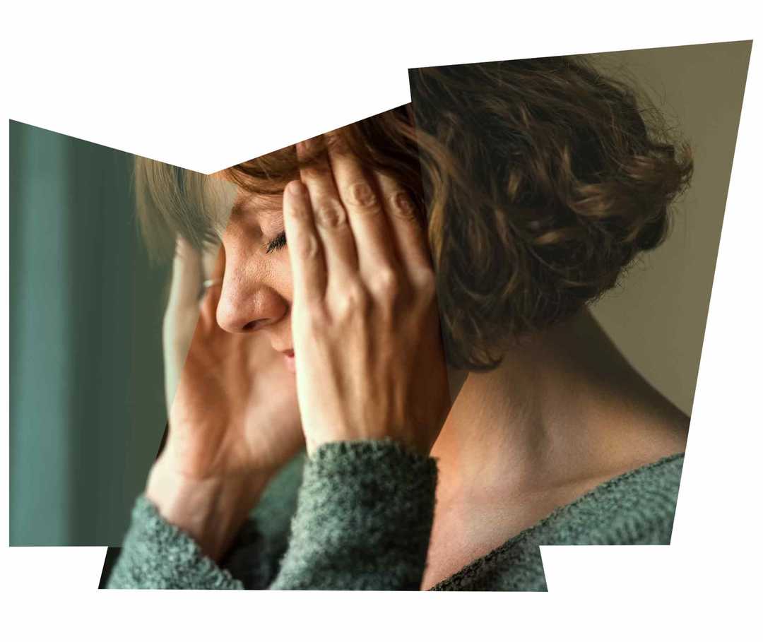 Eine dunkelhaarige Frau massiert ihre Schläfen