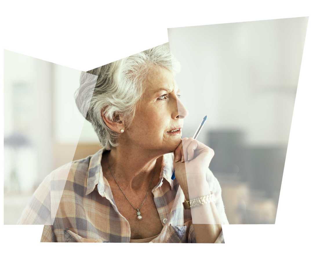 Eine ältere Frau schaut nachdenklich in die Ferne