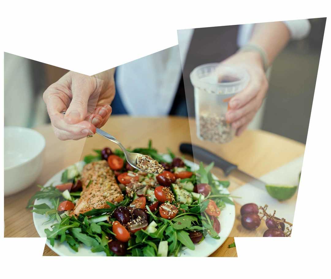 Leben mit NET: Eine Frau garniert inen selbst zubereiteten Salat Leben mit NET: Eine Frau garniert inen selbst zubereiteten Salat