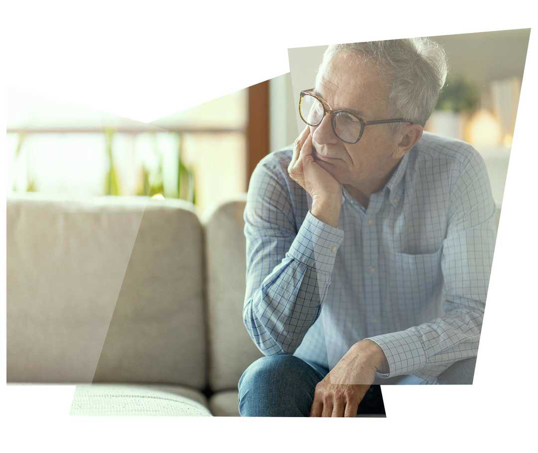 Leben mit NET: Ein Patient, der gerade seine Diagnose bekommt hat, sitzt nachdenklich auf einem Sofa Leben mit NET: Ein Patient, der gerade seine Diagnose bekommt hat, sitzt nachdenklich auf einem Sofa