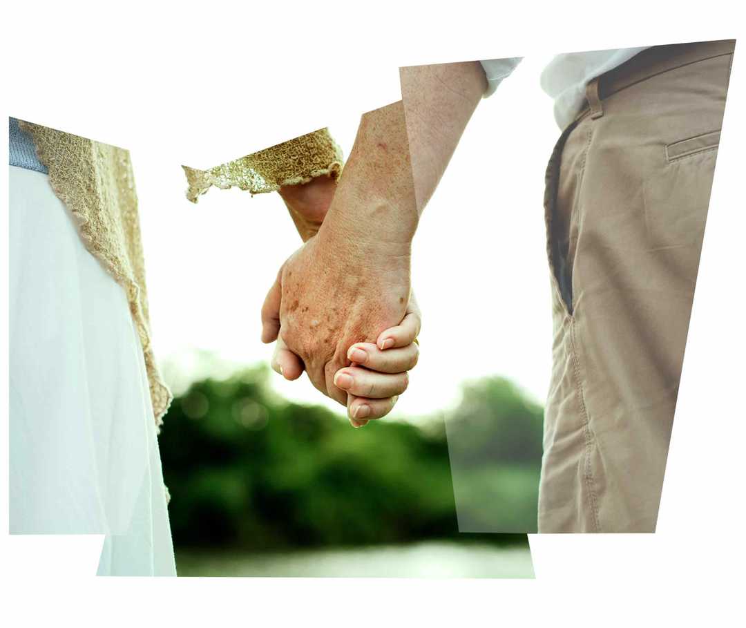 Leben mit NET: Ein älteres Paar steht Hand in Hand an einem Gewässer